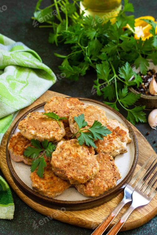 Preview: Healthy vegan food. Red fish cutlets on a dark stone or slate table.