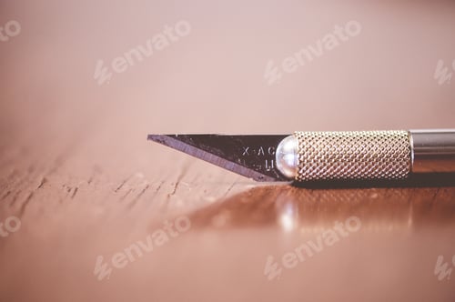 Preview: Closeup shot of a stationery knife on the table with a blurred background