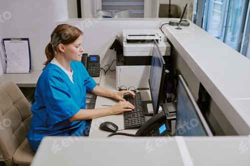 Preview: Caucasian Middle Aged Woman Working at Computer in Medical Reception Area