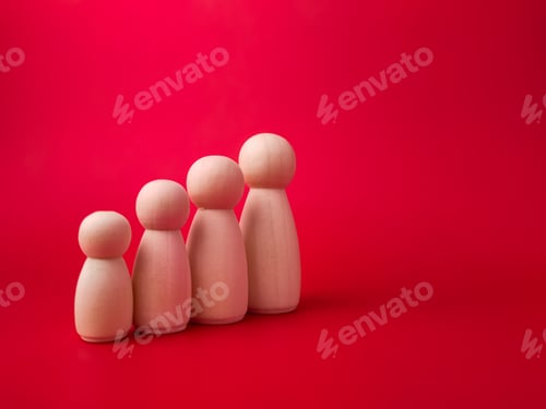 Preview: Wooden figures lined up according to their respective heights on red background with copy space.