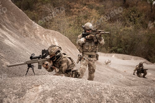 Preview: Soldiers aiming with their rifles
ready to fire during military operation in the desert