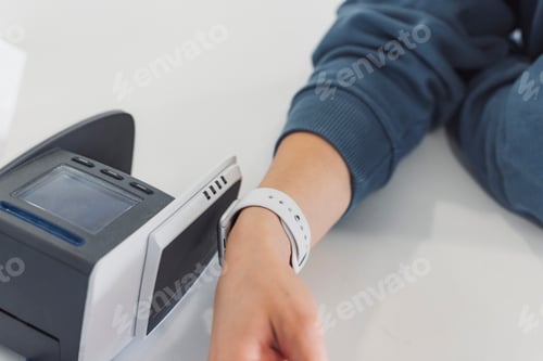 Preview: A close-up of a person's hand resting on a table, wearing a smartwatch. In the background, a blood p
