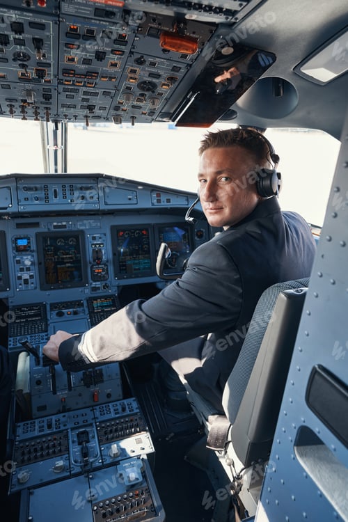 Preview: Male co-pilot looking at camera while pulling an arm lever