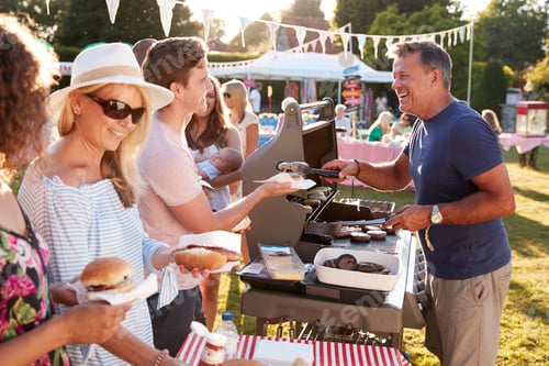 Preview: Man Serving On Barbeque Stall At Summer Garden Fete
