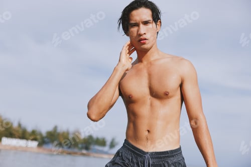 Preview: Smiling Asian Man Enjoying Tropical Swim in Blue Ocean Water on Summer Vacation