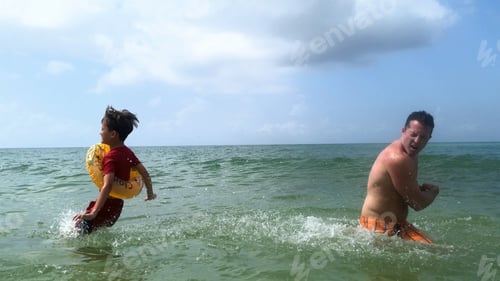 Boy and Man Enjoying the Ocean Together