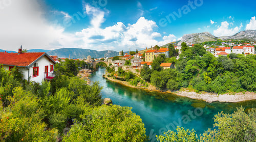 Preview: Fantastic Skyline of Mostar with the Mostar Bridge, houses and minarets, during sunny day.