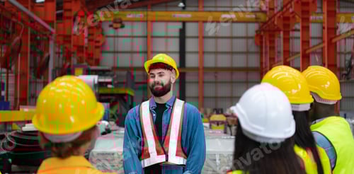 Preview: Supervisor and group of factory workers wearing hard hats meeting brief together