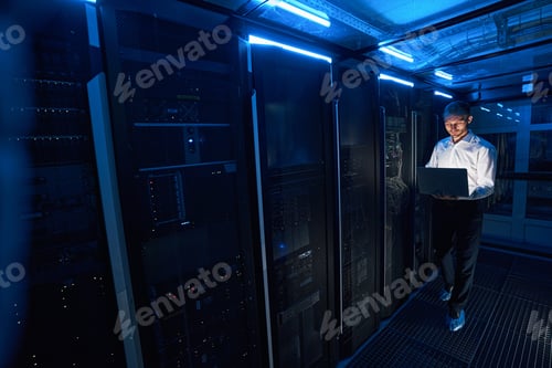 Preview: Concentrated server administrator checking network parameters with laptop