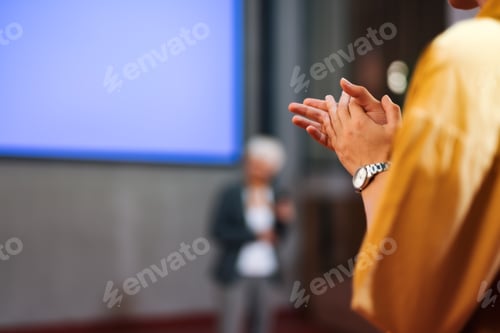 Preview: Female person clapping hands in the public, wearing a wrist watch.
