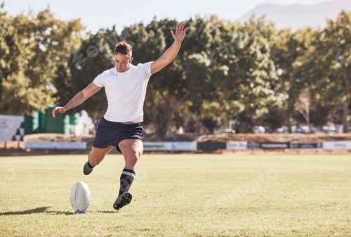 Preview: One caucasian rugby player kicking off during a rugby match outside on the field. Young athletic ma