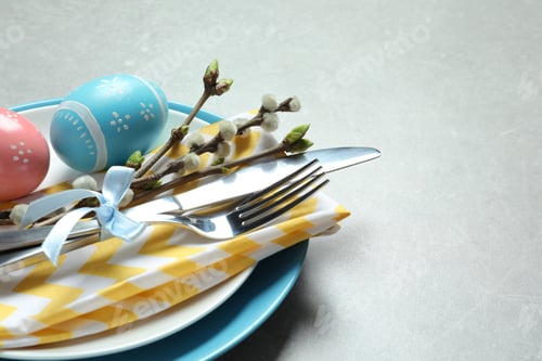 Preview: Festive Easter table setting with painted eggs on color background, closeup. Space for text