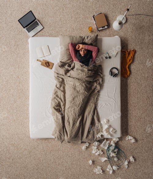 Preview: Sick woman lying in bed, top view