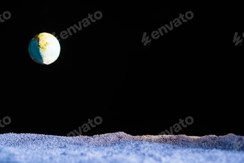 Preview: sandy ground with blurred planet Earth in space isolated on black