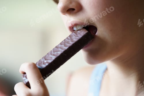 Preview: Crop unrecognizable teenage girl eating healthy protein bar