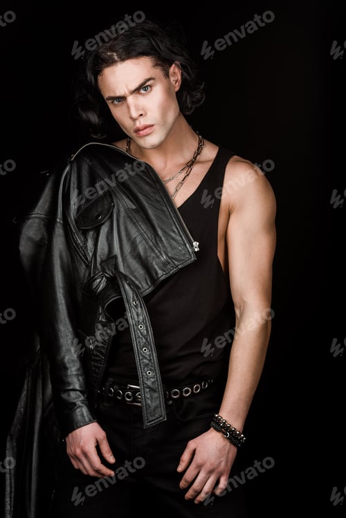 Preview: handsome and serious man in leather jacket looking at camera isolated on black