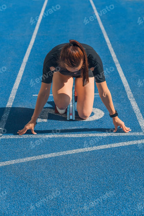 Preview: Female athlete taking position on her marks to start off the run