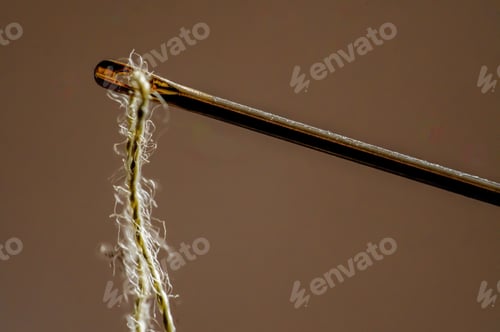 Preview: Close-up shot of a partially unraveled strand of yarn in a needle