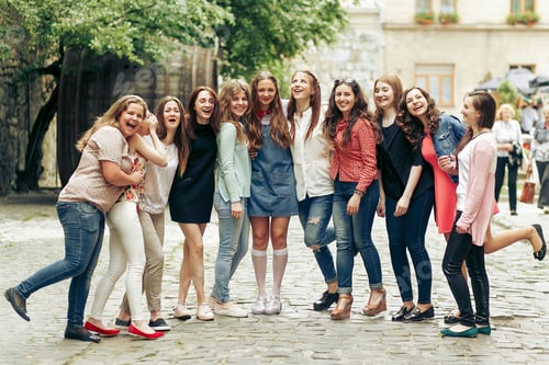 Preview: Group of happy stylish women posing on background of old european city street