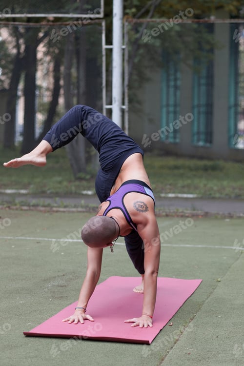 Preview: athletic woman doing yoga outdoor on summer lawn