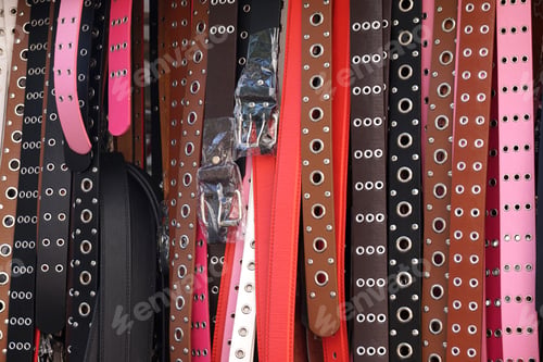 Preview: Closeup shot of colorful leather belts with rivets for sale