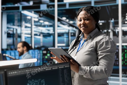 Preview: Portrait of smiling data center programmer using tablet to update servers tech