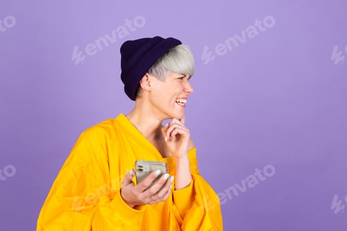 Preview: Stylish european woman on purple background thinking dreaming worry holding mobile phone