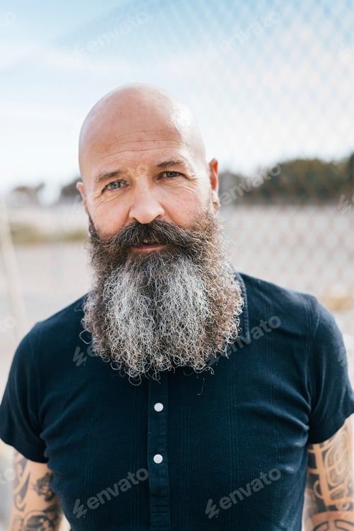 Preview: Confident man with a wellgroomed beard standing outdoors