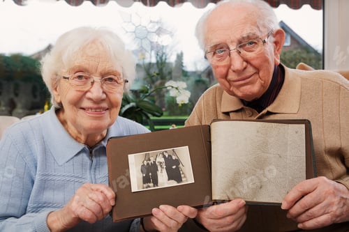 Preview: Senior couple showing old photograph of wedding day