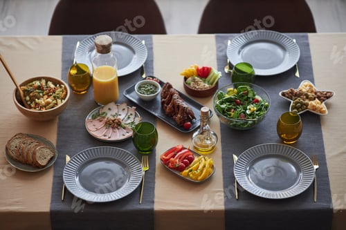 Preview: Food on Small Dinner Table Set for Four People with Blue Color Decor