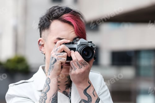 Preview: Front portrait of alternative non-binary male model using film camera.