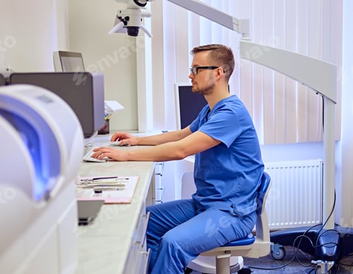 Preview: Man Working at Desk in Medical Office