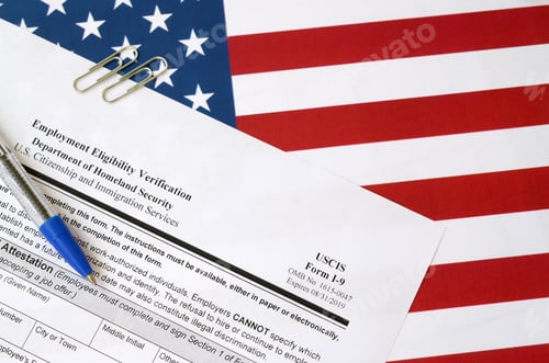 Preview: I-9 Employment Eligibility Verification blank form lies on United States flag with blue pen