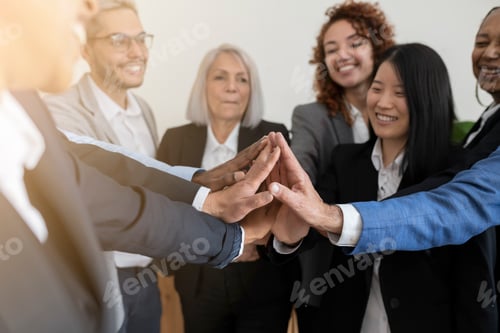 Preview: group of business workers of different ages put their hands together