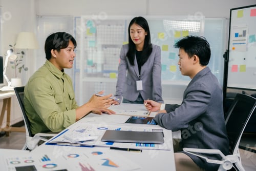Preview: Asian business team discussing financial report in office meeting