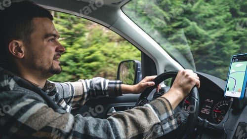 Preview: A man driving a car rides in a mountainous forest area.