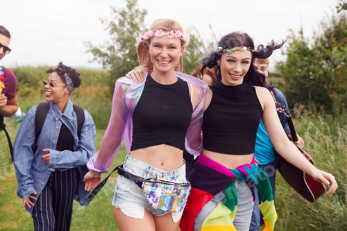 Preview: Group Of Excited Young Friends Carrying Camping Equipment Through Field To Music Festival