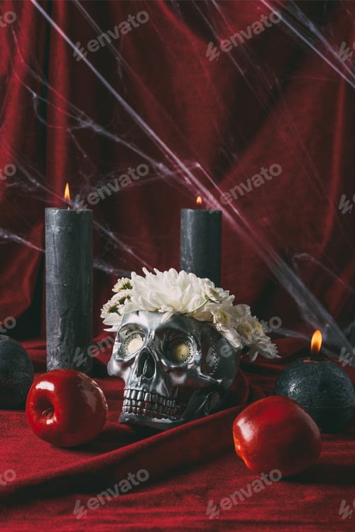 Preview: silver skull with flowers, candles and apples on red cloth with spider web