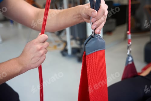 Preview: Rehabilitation therapist works with a female patient on redcord