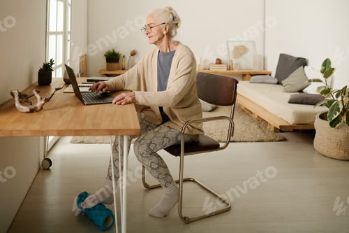 Preview: Senior woman using massage roller