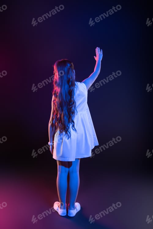 Preview: Smart Child. Clever Dark-Haired Girl Touching An Imaginary Window And Wearing A Lovely Dress