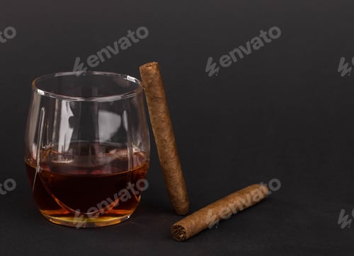 Whiskey Glass and Cigars on a Dark Background