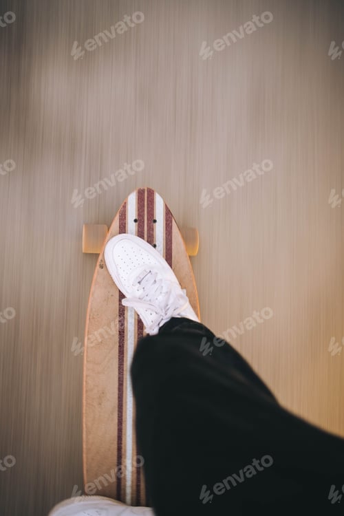 Preview: A photo in color of a skater looking at his feet on the skateboard.