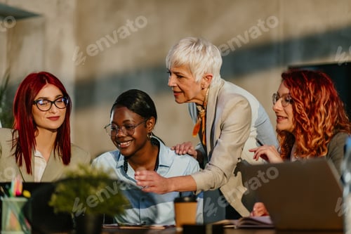 Preview: Interracial female team learning business strategy with their mentor.