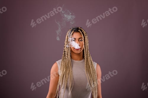 Preview: Portrait of young multiracial woman smoking, studio shoot.
