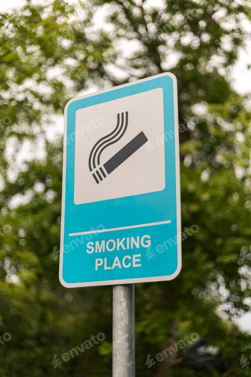 Preview: The sign shows a clear symbol and text indicating a smoking place, positioned among lush trees