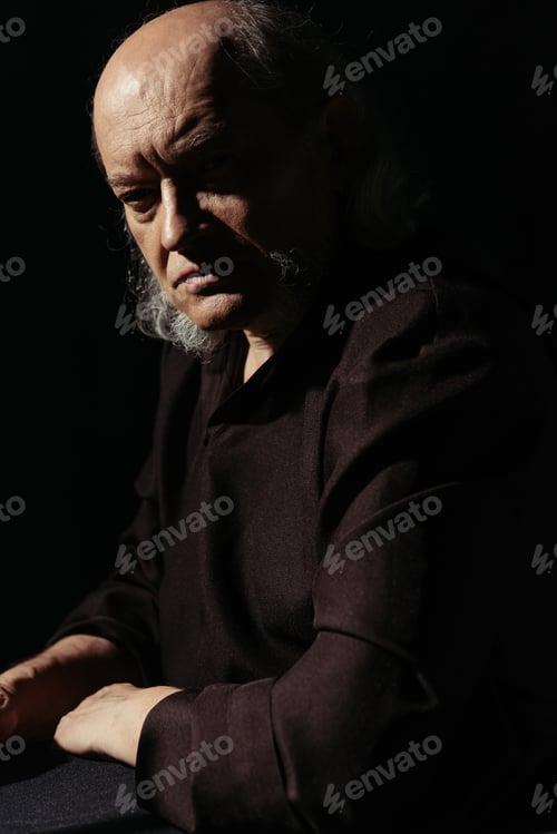 Preview: strict and thoughtful priest looking at camera isolated on black