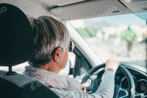 Preview: Happy owner. Handsome mature woman sitting relaxed in his newly bought car looking at the road