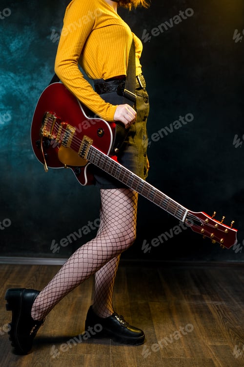Preview: Close-up photo of young hipster woman legs and red guitar in neon lights.