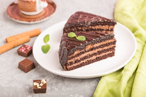 Preview: Homemade chocolate cake with milk cream and a cup of coffee on a gray concrete background
